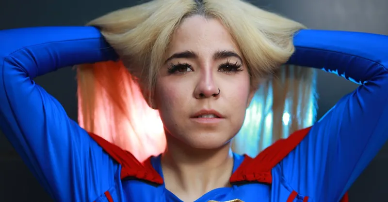 Close-up of a woman in superhero costume striking a confident pose, embodying empowerment.