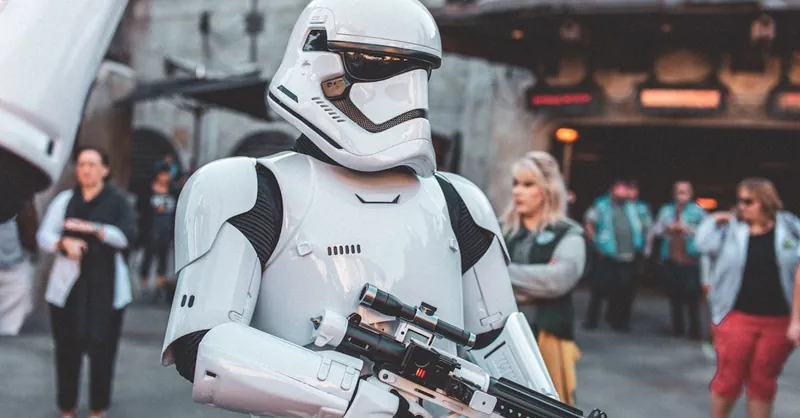 Stormtrooper character in costume at a busy sci-fi themed park event.