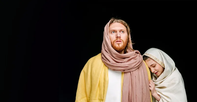 Portrait of two people in traditional robes against a black background, symbolizing religious themes.