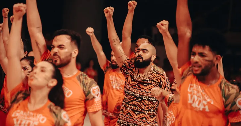 Vibrant group of diverse young adults raising fists, celebrating and uniting in brightly colored outfits.