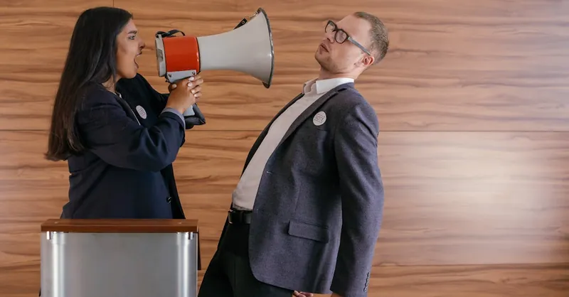 Dynamic image of two politicians arguing; one shouts into a megaphone in a heated debate.